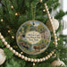 A round ornament hanging on a Christmas tree, featuring a scenic image of the Old Erie Canal and historic park in New York.
