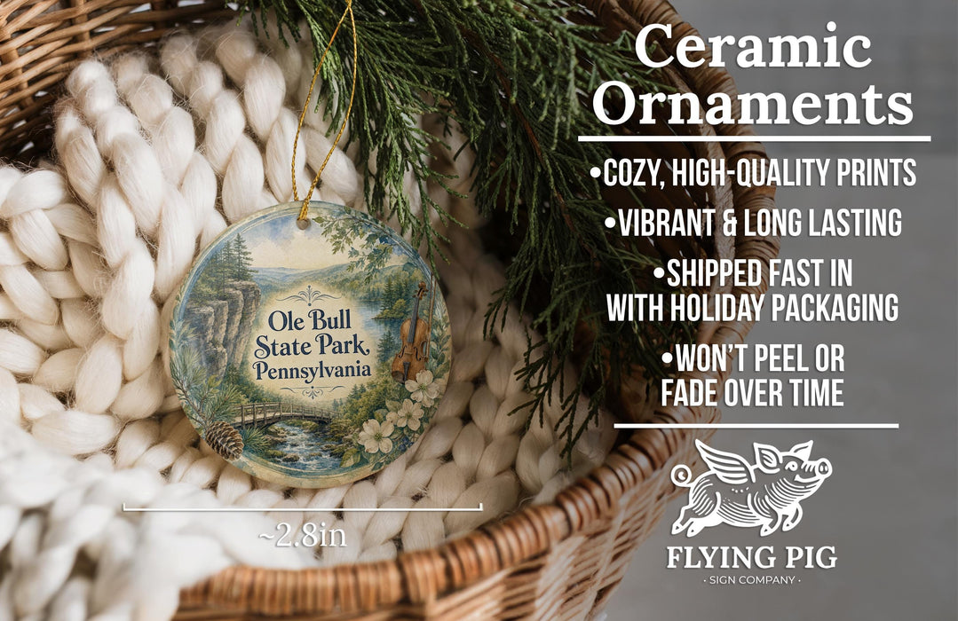 Ceramic ornaments, featuring a painting of the Ole Bull State Park in Pennsylvania, are displayed in a wicker basket.