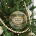 A round ornament hanging on a Christmas tree, featuring a scenic image of the Oquaga Creek State Park in New York.