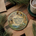A round ornament with a scenic image of Ozark Caves at Lake of the Ozarks State Park, Missouri, hanging on a wooden surface.