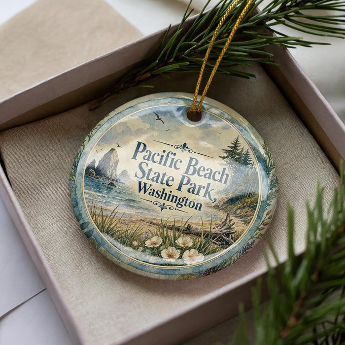 A decorative ornament in a box, featuring a scenic image of Pacific Beach State Park in Washington.