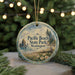 A round ornament with a scenic image of Pacific Beach State Park, Washington, featuring a beach, mountains, and pine trees.