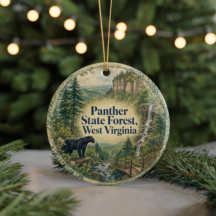 A round ornament featuring a scenic image of the Panther State Forest in West Virginia, with a black panther standing on a rock and surrounded by pine trees and a waterfall.