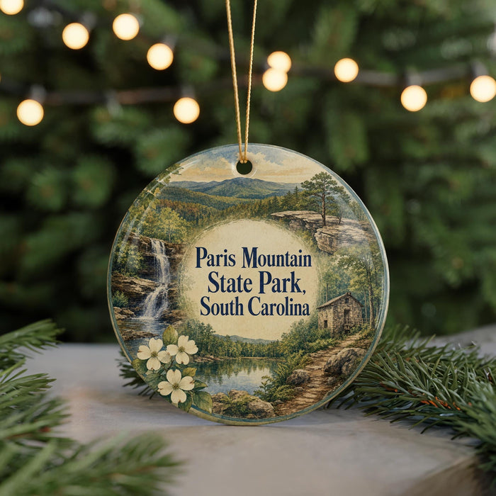 A decorative ornament featuring a scenic landscape with a waterfall, surrounded by pine trees and greenery, with the text "Paris Mountain State Park, South Carolina" prominently displayed.