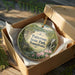 A decorative ornament in a brown box, featuring a scenic image of Paterson State Park in Pennsylvania.