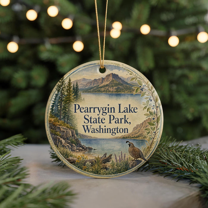 A circular ornament featuring a scenic landscape of Pearyrin Lake, State Park, and Washington, with a bird perched on a tree branch in the foreground.