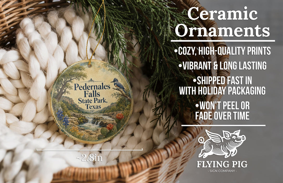 Ceramic ornaments, featuring a detailed illustration of the scenic Pelermates Falls State Park in Texas, are displayed in a woven basket. The text highlights the ornaments as "cozy, high-quality prints" and "vibrant and long lasting", with a description of their shipping speed and the fact that they won't peel or fade over time.