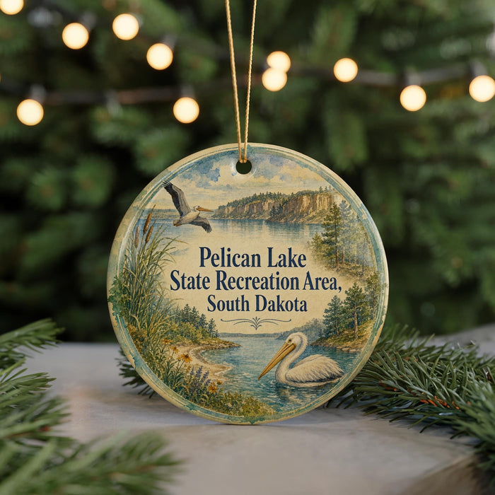 A round ornament with a scenic image of Pelican Lake, the Pelican Lake State Recreation Area in South Dakota, featuring a pelican and a lake surrounded by trees.
