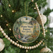 A round ornament hanging on a Christmas tree, featuring a scenic image of the Penn State Forest in New Jersey.