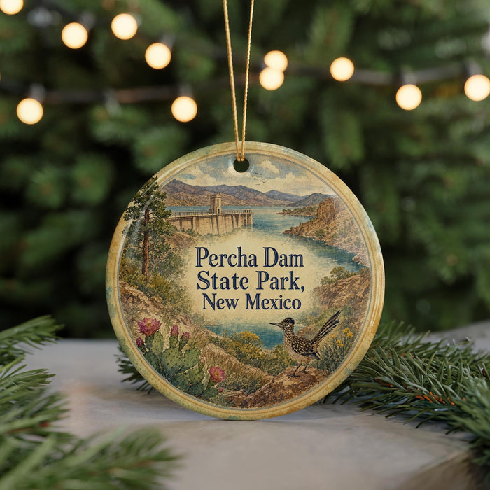 A round ornament with a painting of Percha Dam, a landmark in New Mexico, featuring a bird and a scenic landscape.