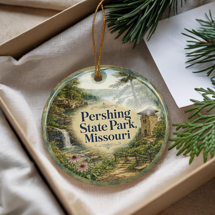 A decorative ornament with a scenic landscape of Pershing State Park, Missouri, featuring a waterfall, pine trees, and a stone tower.