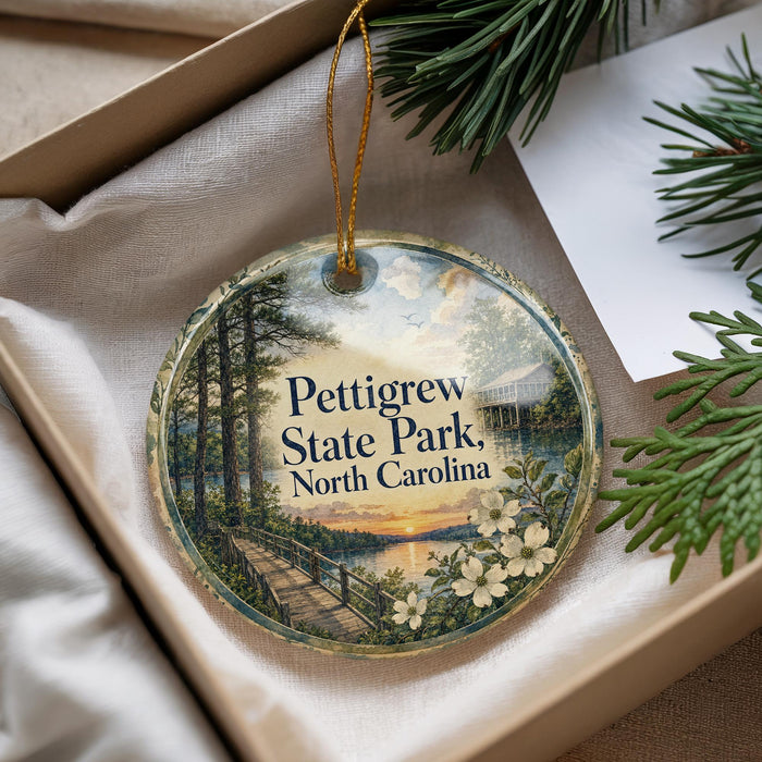 A decorative ornament with a scenic image of Petigrew State Park, North Carolina, hanging from a string.