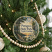 A round ornament hanging on a Christmas tree, featuring a scenic image of Pettigrew State Park in North Carolina.