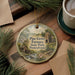 A round ornament with a painting of Pine Grove Furnace State Park, Pennsylvania, hanging on a wooden surface.