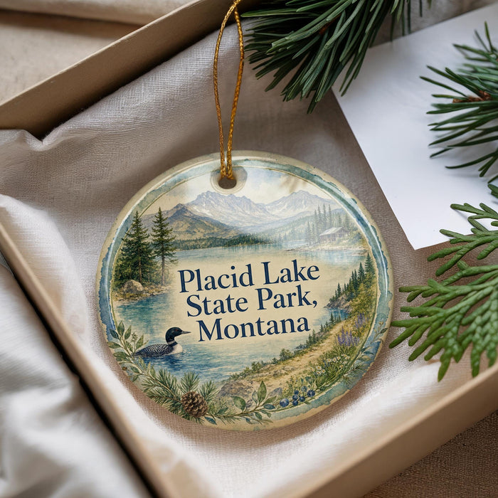 A decorative ornament with a scenic landscape of Placid Lake, State Park, Montana, featuring a duck swimming in the water and pine trees in the background.