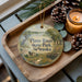 A decorative ornament with a scenic image of Platte River State Park, Nebraska, is displayed on a wooden tray alongside pine cones and a lit candle.