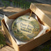 A decorative ornament in a brown box, featuring a scenic image of the Platte River State Park in Nebraska.