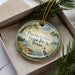 A decorative ornament in a box, featuring a scenic image of Purtis Creek State Park in Texas.