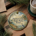 A decorative ornament with a scenic image of Purtis Creek State Park, Texas, featuring a bird, a lake, and pine trees.