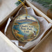 A decorative ornament in a box, featuring a scenic image of Quail Creek State Park in Utah.