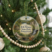 A round ornament hanging on a Christmas tree, featuring a scenic image of Pennsylvania State Park with a waterfall and a bridge.