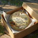 A decorative ornament in a wooden box, featuring a scenic image of Red Clay State Historic Park in Tennessee.