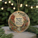 A decorative ornament featuring a scenic landscape with a waterfall and mountains, hanging on a string.