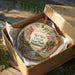 A decorative ornament in a wooden box, featuring a scenic image of the Red Rock Canyon State Park in Oklahoma.