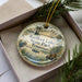 A decorative ornament with a scenic image of Reelfoot Lake State Park in Tennessee, featuring a bird, palm trees, and a body of water.