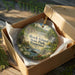 A decorative ornament in a box, featuring a scenic landscape with a waterfall and lush greenery, with the text "Rock Island State Park, Tennessee" prominently displayed.