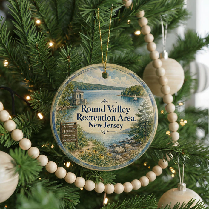A round ornament on a Christmas tree, featuring a scenic landscape with a lake, mountains, and a sign that reads "Round Valley Recreation Area, New Jersey".
