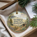 A decorative ornament with the text "Sacajawea State Park, Washington" on it, hanging from a string. The ornament is placed in a box with pine branches and a white paper.