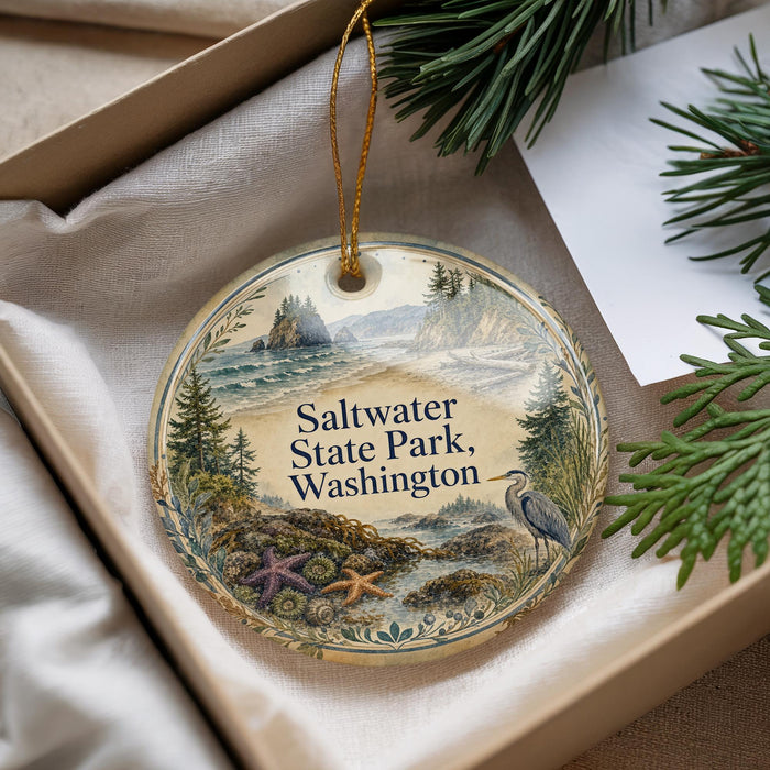 A decorative ornament with a scenic landscape of Saltwater State Park, Washington, featuring a bird, pine trees, and a body of water.