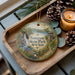 A wooden tray with a decorative ornament featuring a scenic landscape of Sampson State Park, New York, and pine cones.