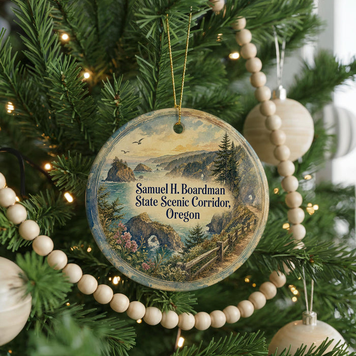 A round ornament hanging on a Christmas tree, featuring a scenic landscape with mountains, a river, and a bridge.