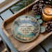 A decorative ornament with a scenic image of Lake Tahoe and Nevada State Park, featuring pine cones and a candle on a wooden tray.