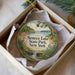 A decorative ornament in a box, featuring a scenic landscape with a lake, trees, and a waterfall.