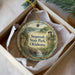 A decorative ornament in a box, featuring a scenic landscape with a waterfall and a castle, with the text "Sequoyah State Park, Oklahoma" printed on it.