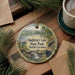A decorative ornament featuring a scenic landscape of Singletary Lake State Park in North Carolina, with pine trees and a waterfall.