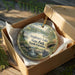 A decorative ornament in a box, featuring a scenic landscape of Singleton Lake, State Park, and North Carolina.