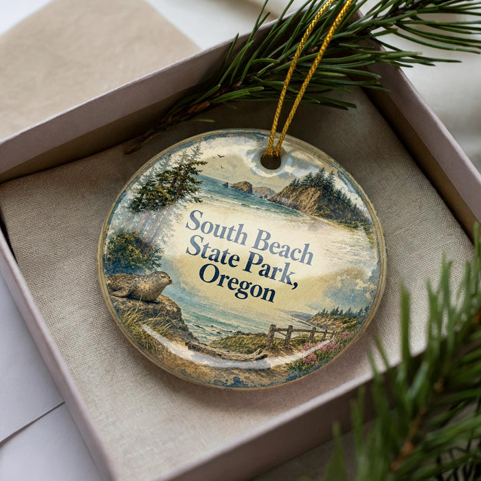 A decorative ornament in a box, featuring a scenic landscape with a body of water, trees, and mountains.