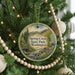 A round ornament hanging on a Christmas tree, featuring a scenic image of Spring Creek State Park in Washington.