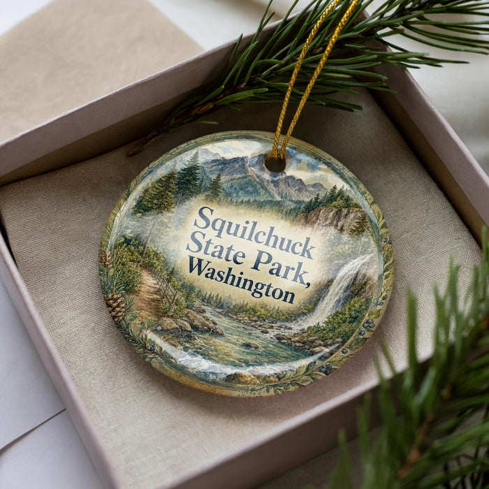 A decorative ornament with a scenic landscape of Squilchuck State Park, Washington, featuring a mountain, river, and pine trees.