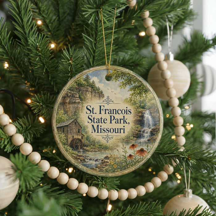 A round ornament hanging on a Christmas tree, featuring a scenic image of St. Francois State Park, Missouri.
