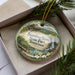 A decorative ornament with a scenic landscape of Standing Stone State Park, Tennessee, featuring a waterfall and pine trees.