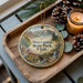 A wooden tray with a decorative ornament featuring a scenic landscape of Stravation State Park, Utah, and pine cones.