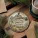 A decorative ornament featuring a scenic image of Steamboat Rock State Park in Washington, surrounded by pine branches and a cup of coffee on a wooden surface.