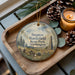 A wooden tray with a decorative ornament featuring a scenic landscape of Steptoe Battlefield State Park, Washington, accompanied by pine cones and a lit candle.