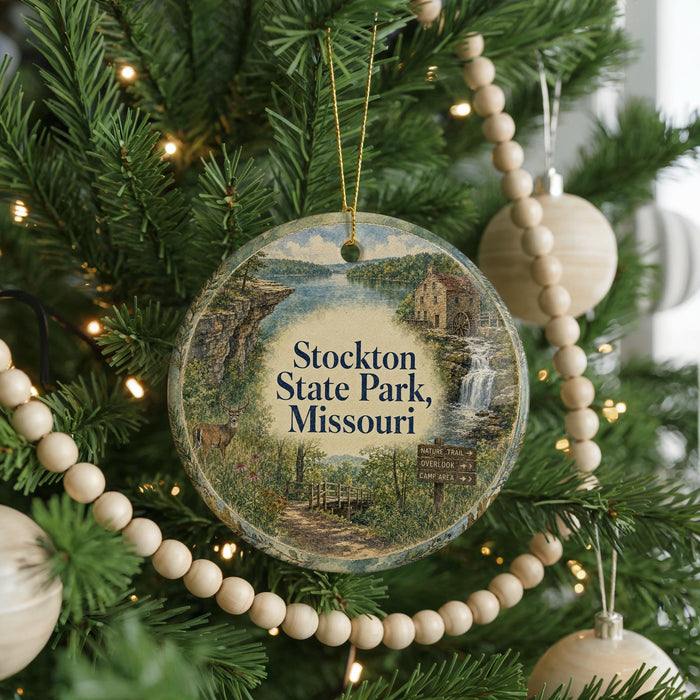 A round ornament hanging on a Christmas tree, featuring a scenic image of Stockton State Park, Missouri.