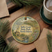 A decorative ornament featuring a scenic landscape of Sully Creek State Park in North Dakota, with a small cabin and a bridge in the foreground.